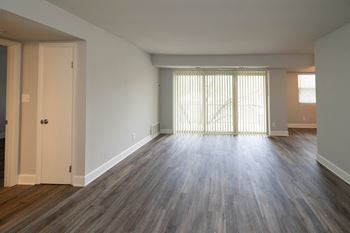 Living space with hardwood flooring and a door leading to a balcony
